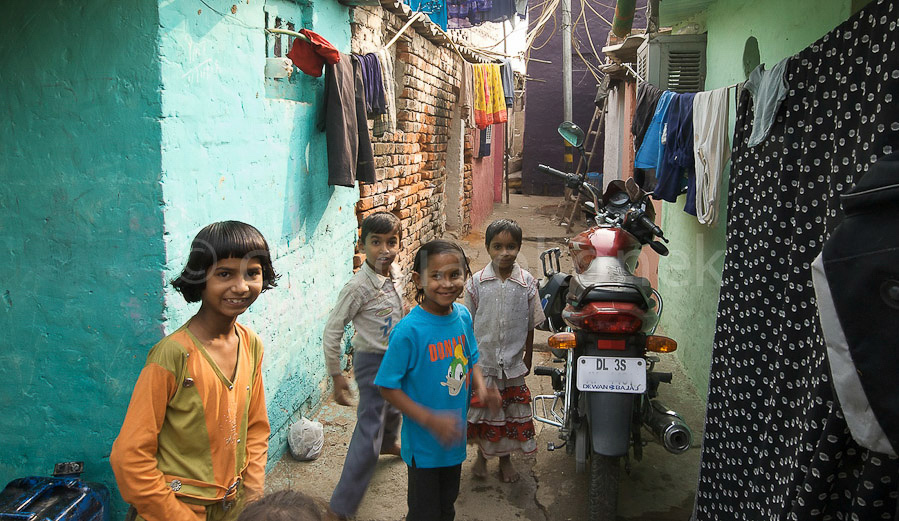 Weg zwischen den Häusern in einem Slum. Nicht alle Bewohner eines Slum sind mittellos.