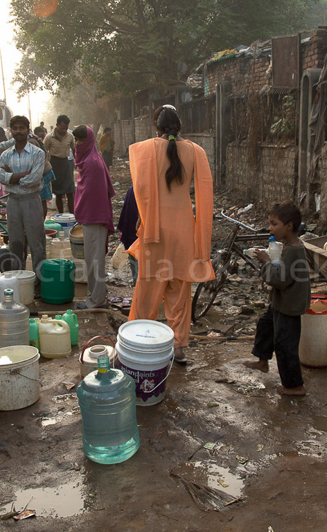 Eine junge Frau die im Slum zu Hause ist, geht zur Arbeit. Viele Slumbewohner in Delhi arbeiten in wohlhabenden Vierteln.